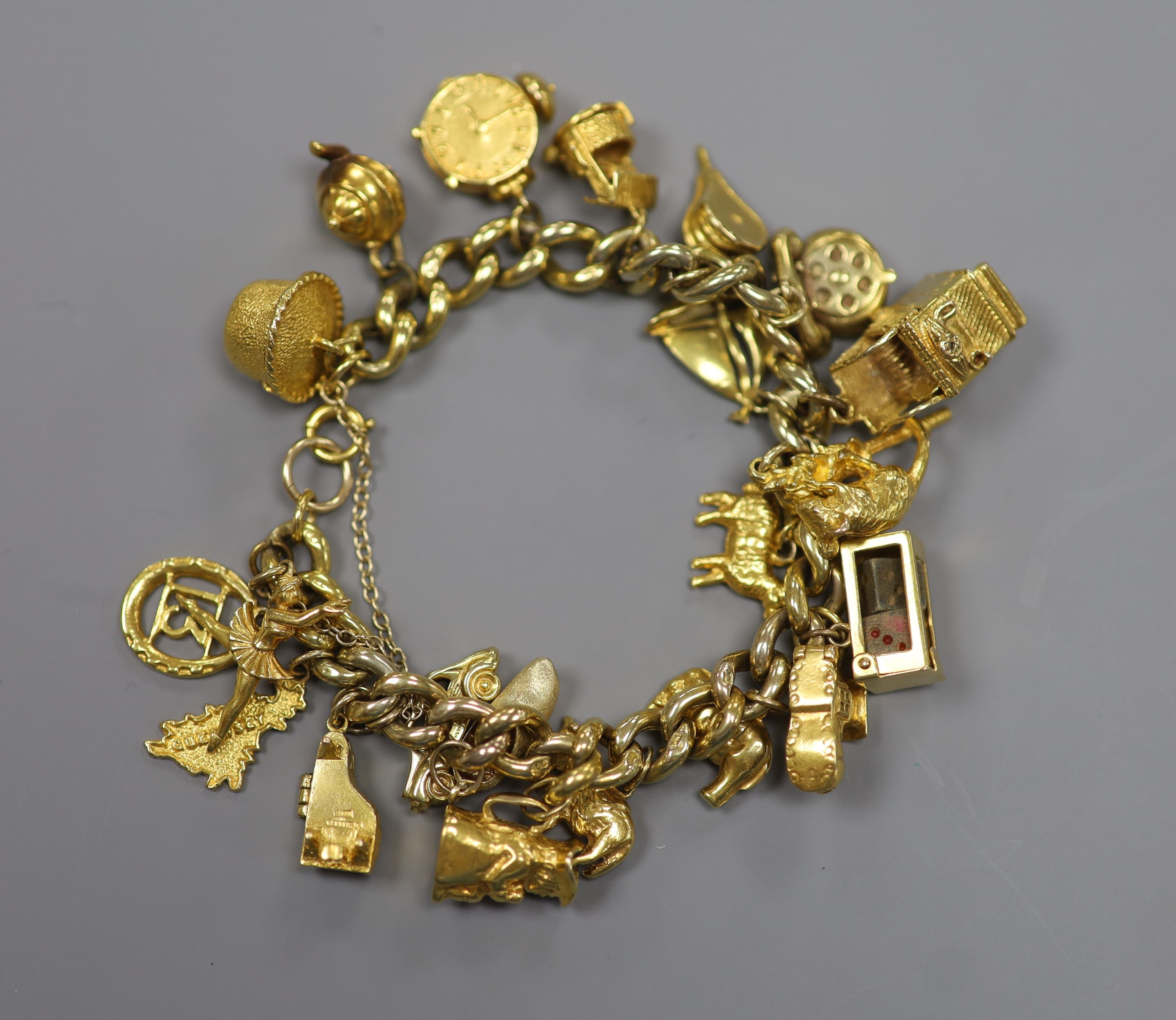 A 9ct curb link charm bracelet hung with twenty one assorted mainly 9ct gold charms